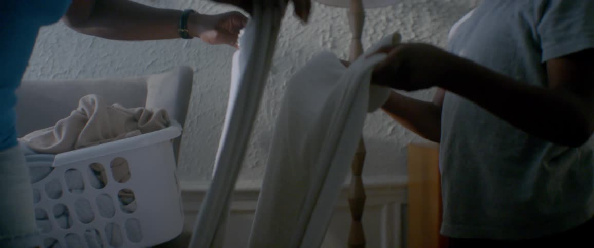 A woman and child fold up some sheets