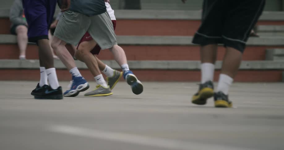 Men play basketball on an outdoor court