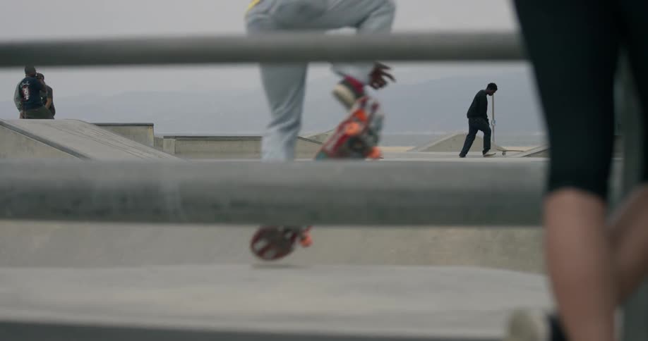 People are skateboarding in a park on a cloudy day
