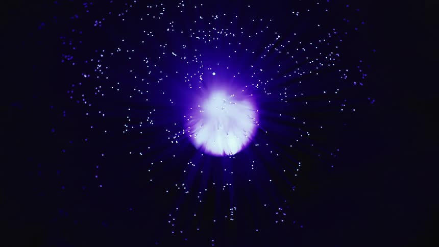Neon stars are projected onto the ceiling in a dark room
