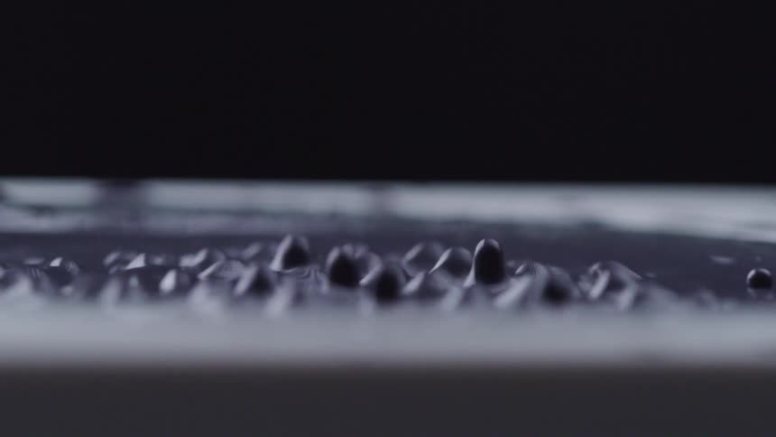 The speaker is vibrating making the liquid jump around