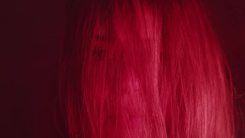 A woman is surrounded by smoke with hair covering her face