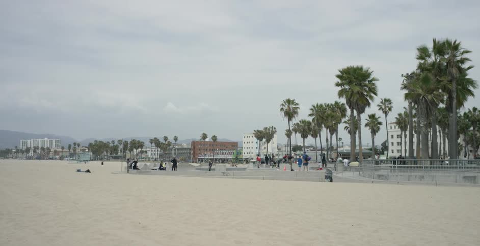 People are playing on a beach on a cloudy day