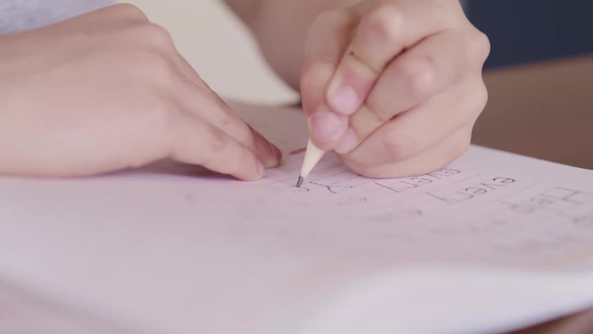 Young children making homework using paper and pencil