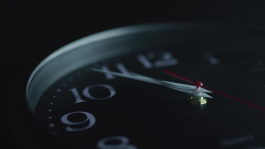 A clock with a red second hand turning