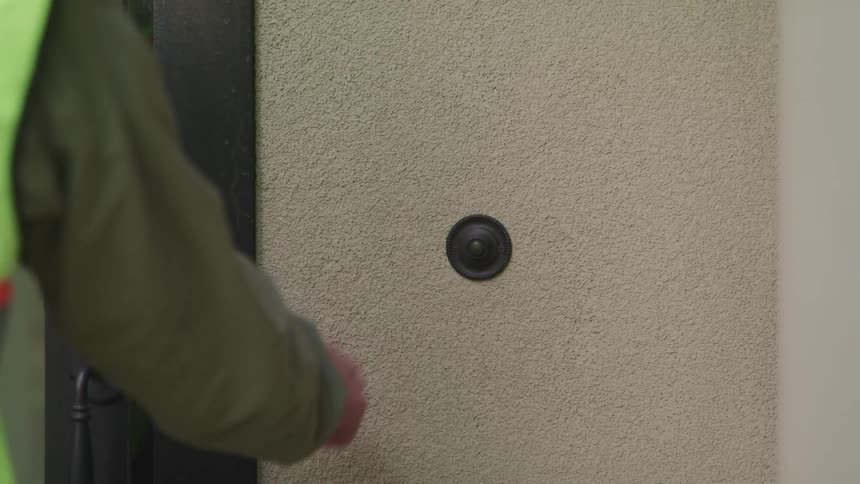 A person rings the doorbell and enters