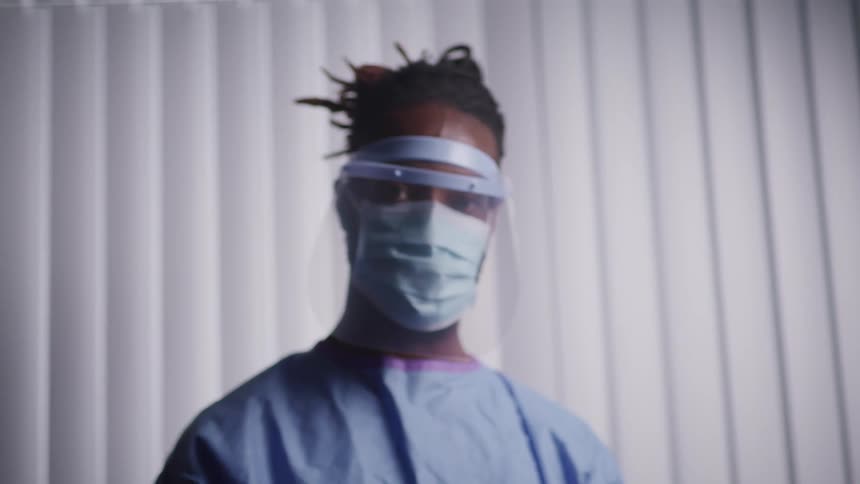 A nurse in a clinic with a mask and gown on