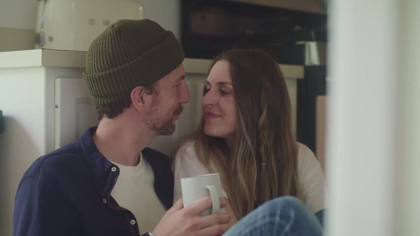 A man and woman are sitting in the kitchen together