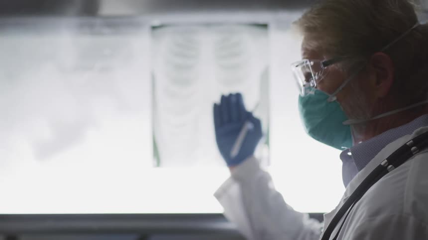 A doctor is pointing out things on an xray