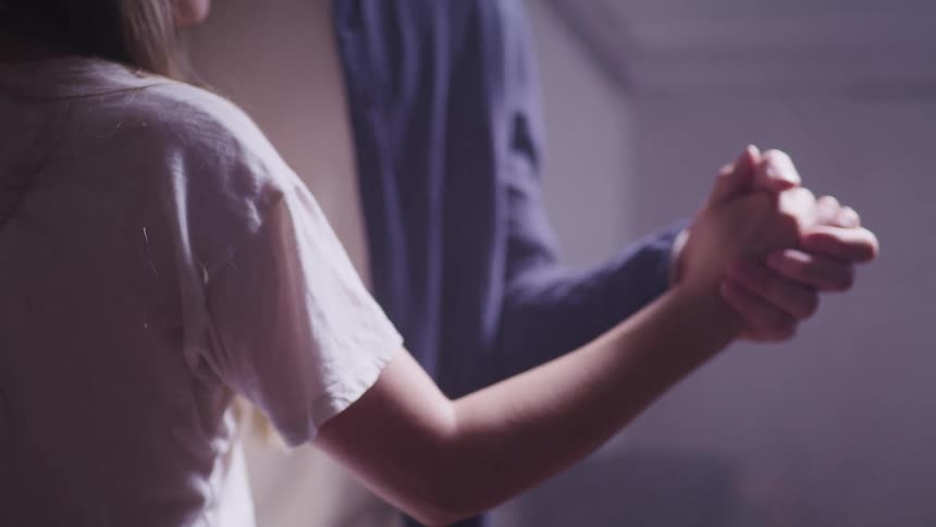 A woman and man are dancing indoors
