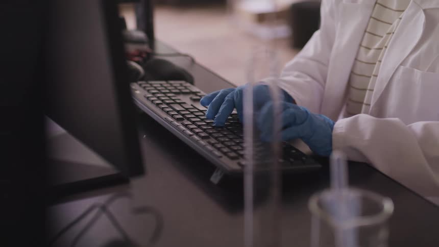 A nurse types on a keyboard