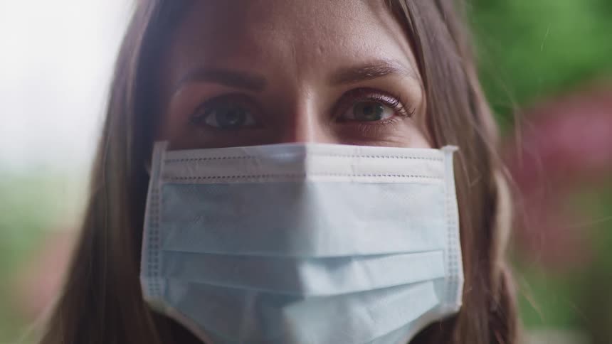 Close up of a woman posing with a facial mask outdoors