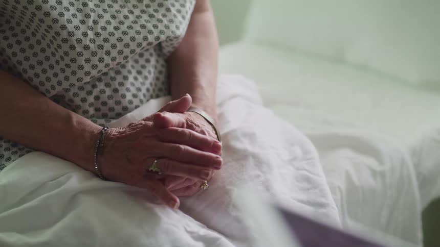 A patient rubs their hands together