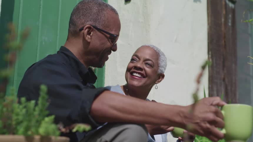 A man and woman are outdoors while holding cups