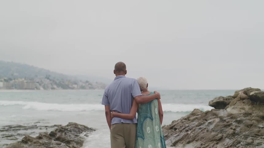 A husband and wife are looking at the ocean