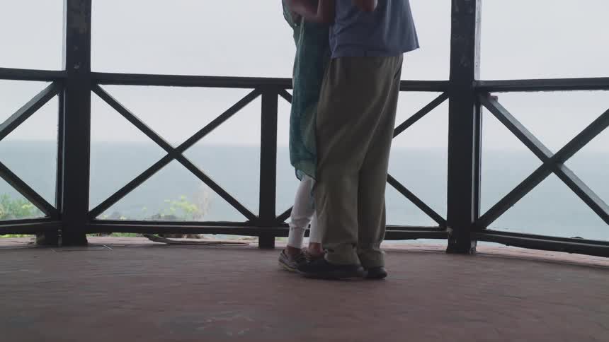 Man and woman embrace as they stand in an outdoor area
