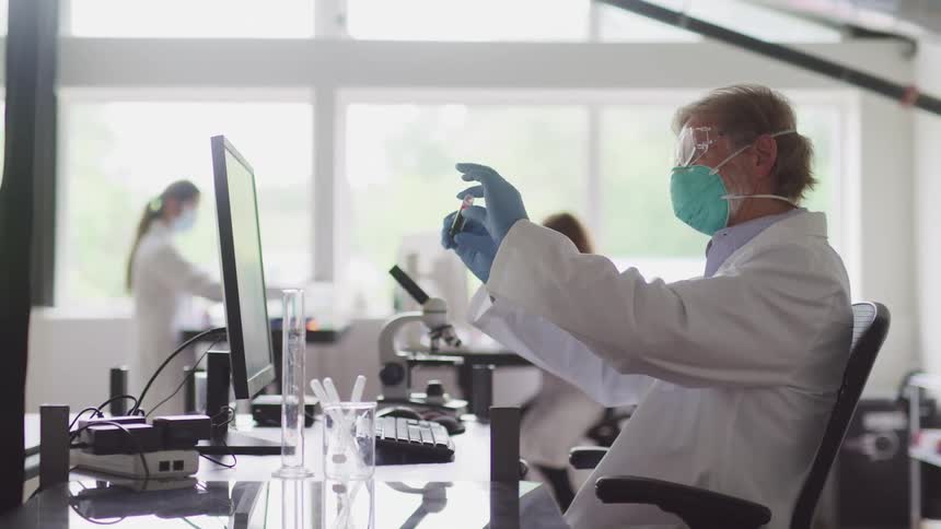 Lab technician performs testing sitting in front of computer monitor