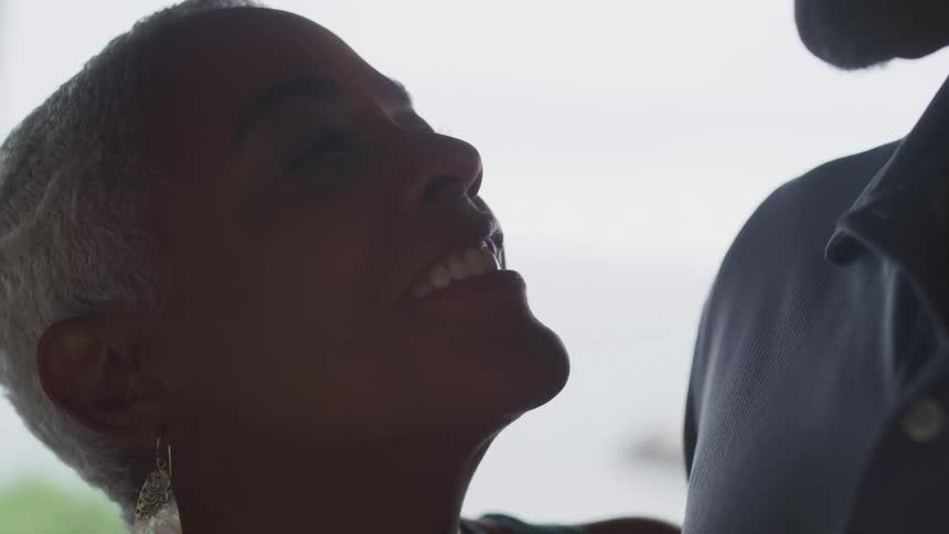 A woman looks up smiling to a talking man