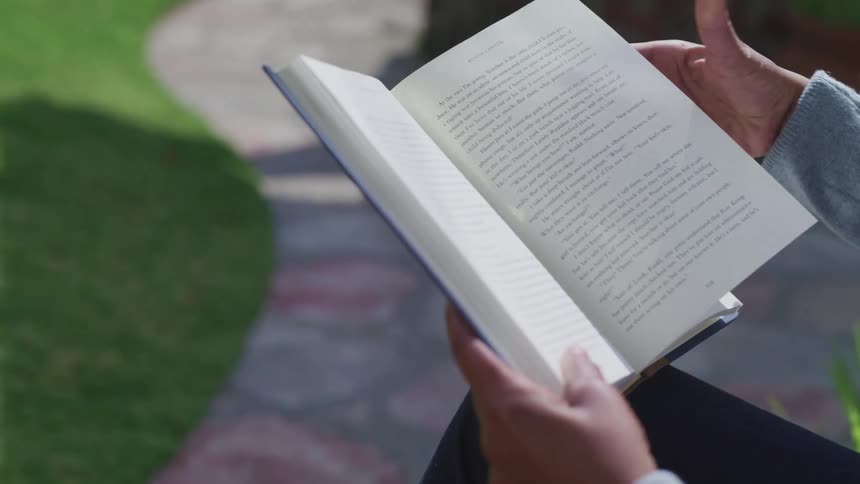 A person is reading a book outdoors