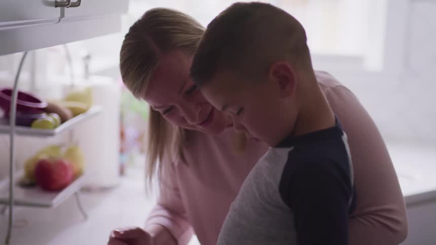 A mother is talking to her son in the kitchen