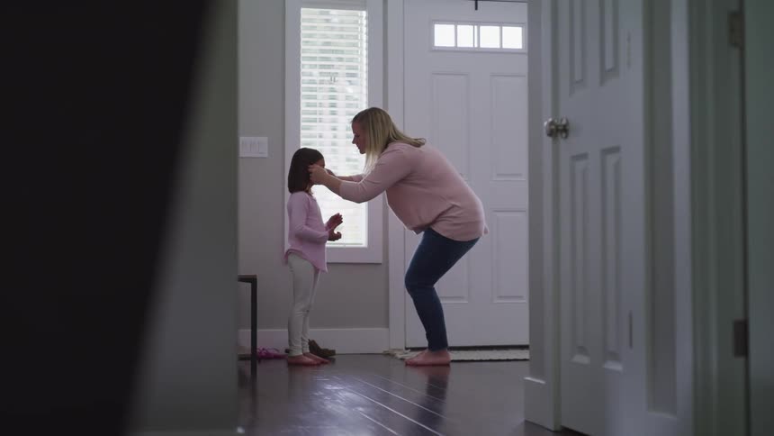 A woman places a mask on a child