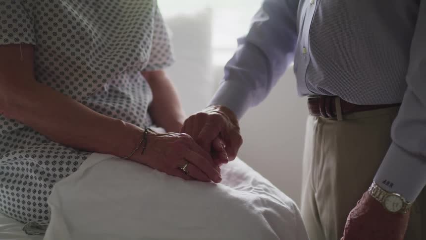 A couple hold hands in the doctors office