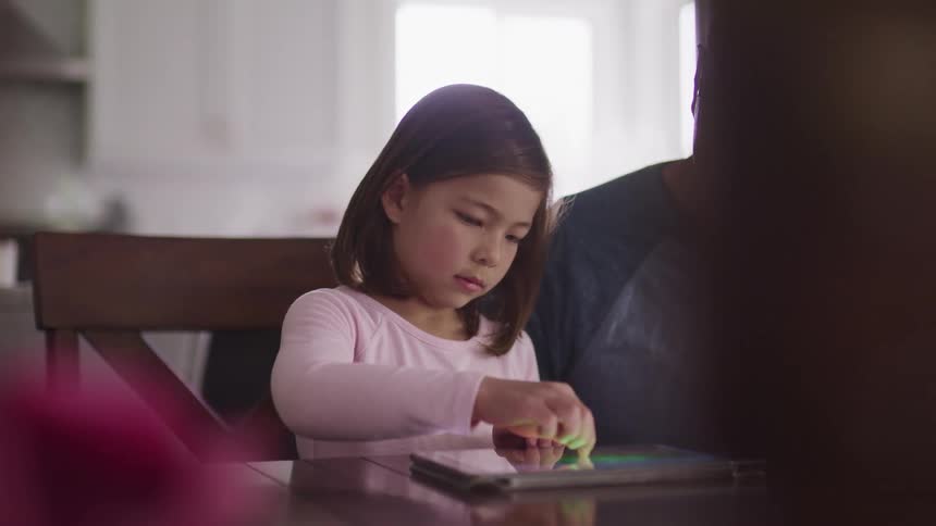 A father and daughter use a tablet together