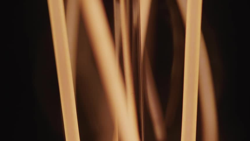 Thin lights tubes come on and off briefly glowing against the surrounding darkness