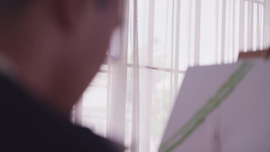 A man is painting a picture indoors
