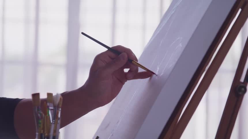 A person is painting with a small brush