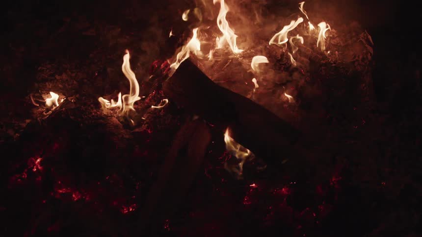 Wood is burning outdoors at night