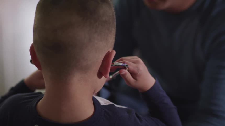 Man helps little boy to hear his own heartbeat with a stethoscope