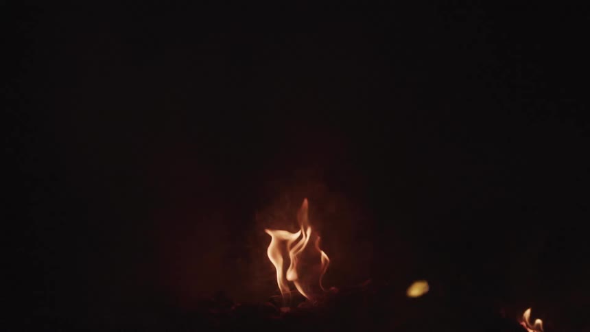 Fire burns creating smoke in darkness
