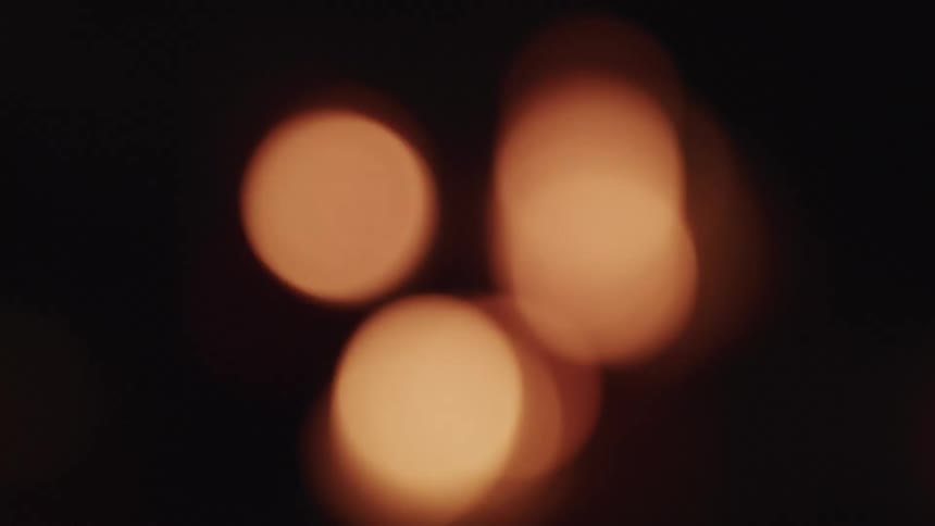 Out of focus footage of orange flames in the dark