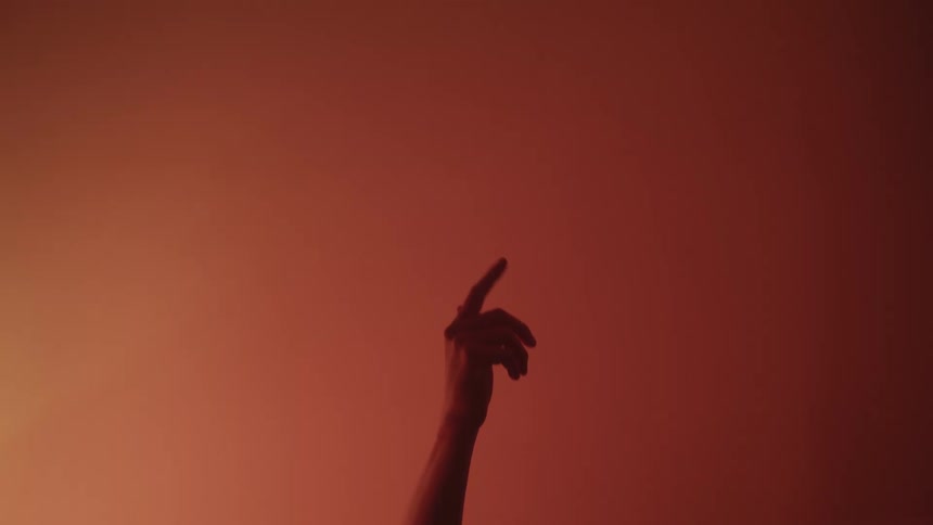 A person reaches their hand up in the dark