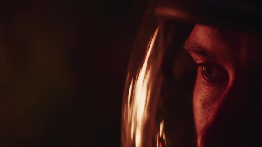 A man with a face shield with a reflection of a fire on it
