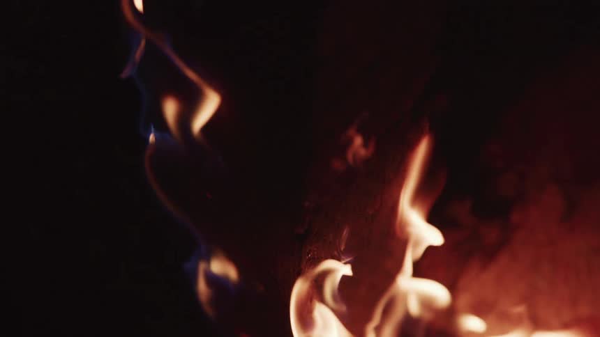 Close up of flames on a burning piece of wood at nigth