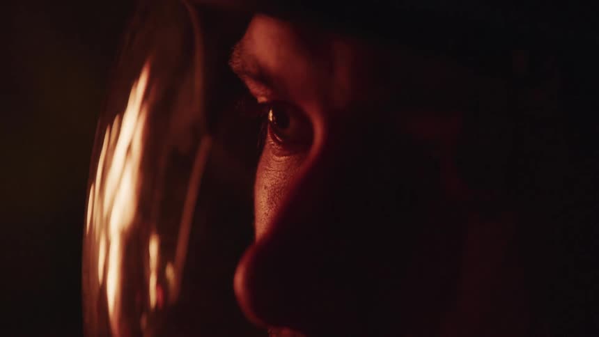 A person watches a fire burn in the dark