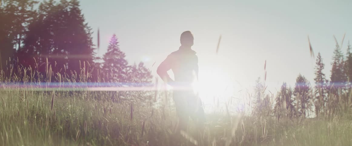 A man is standing outdoors at dusk