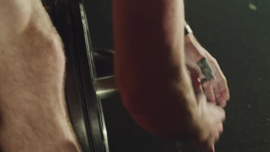 A man adds weights to a barbell in a gym