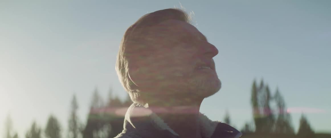 A man is standing outdoors at dusk