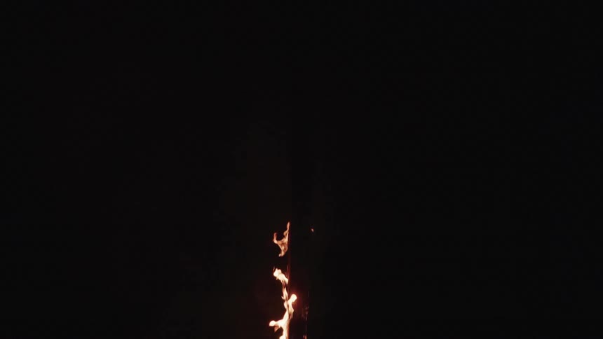 From within a great darkness and flame burns brightly as it engulfs an unseen object