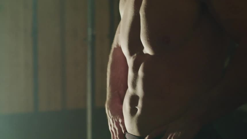 A man has his shirt off in a gym