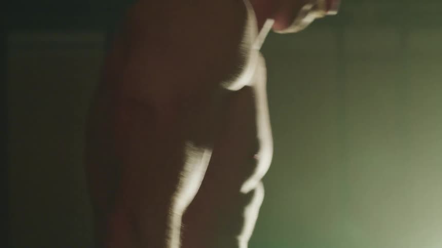 Muscular man lifts up dumbbells in the gym