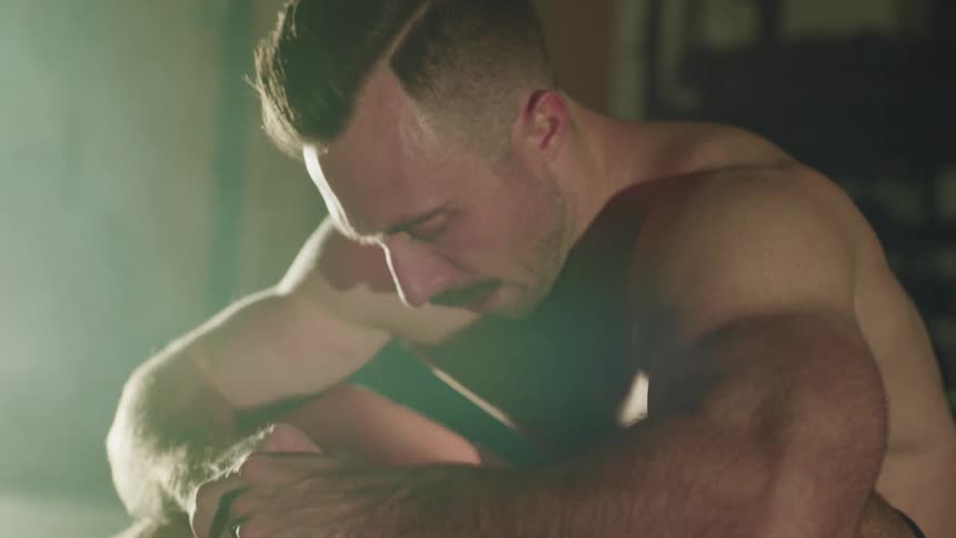 Muscular man takes a break during workout in a gym