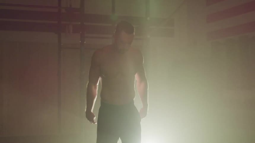 A man rests and bends over in the gym