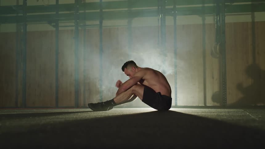 A man is sitting indoors working out