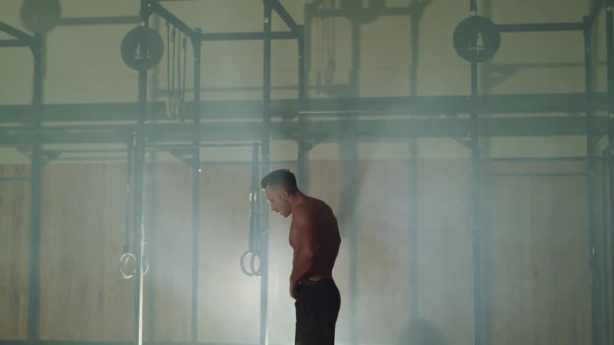 Muscular man takes a break during workout in a gym