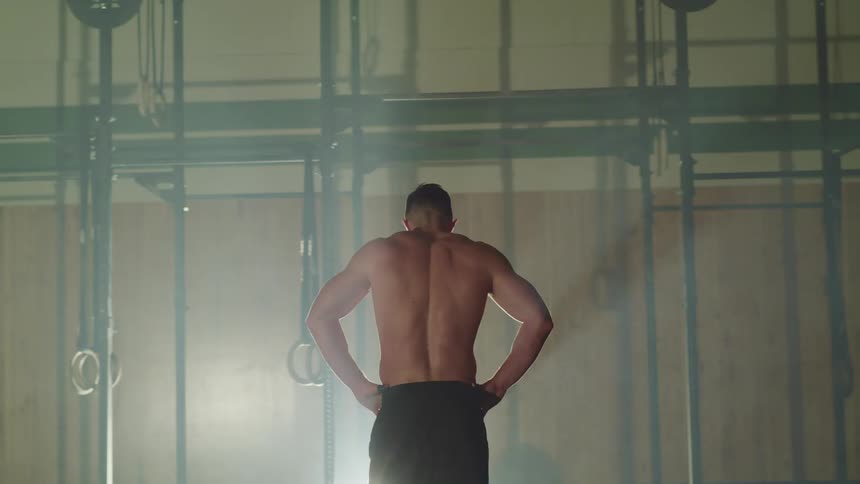 Muscular man takes a break during workout in a gym
