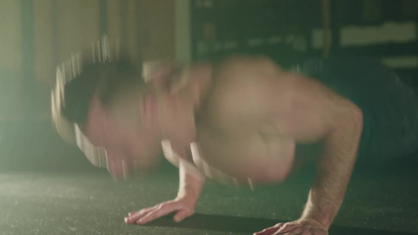 Muscular man with a mustache pushes up in a gym